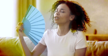 Woman fanning herself in hot room