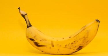 Ripe banana on yellow background.
